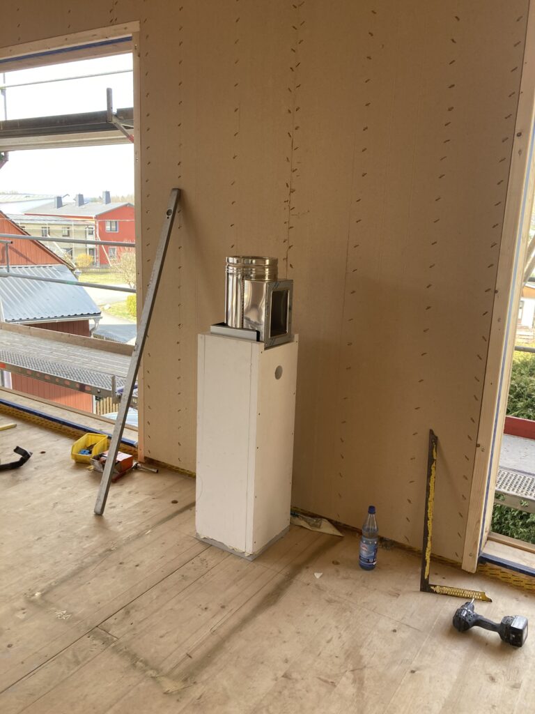 Gedämmtes Schornsteinelement mit weißer Brandschutzbox im Innenraum